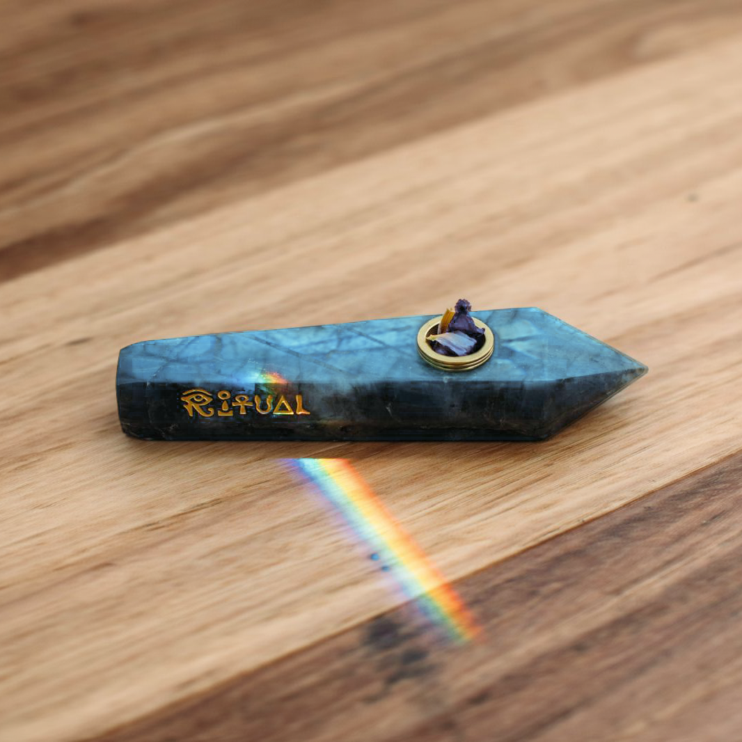 Labradorite pipe casting a rainbow across a wooden surface